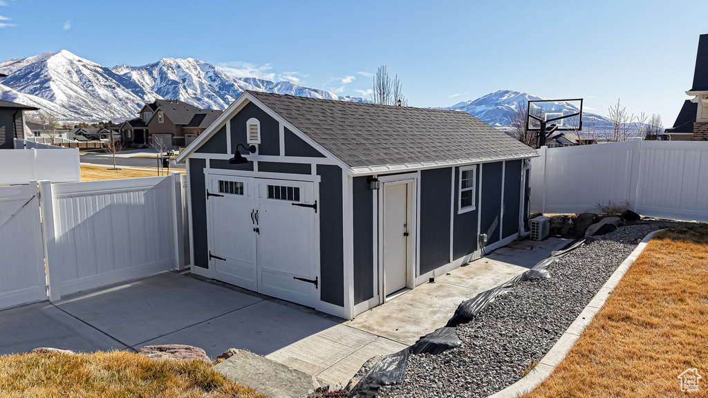 View of outbuilding with a fenced backyard, a mountain view, and an outbuilding