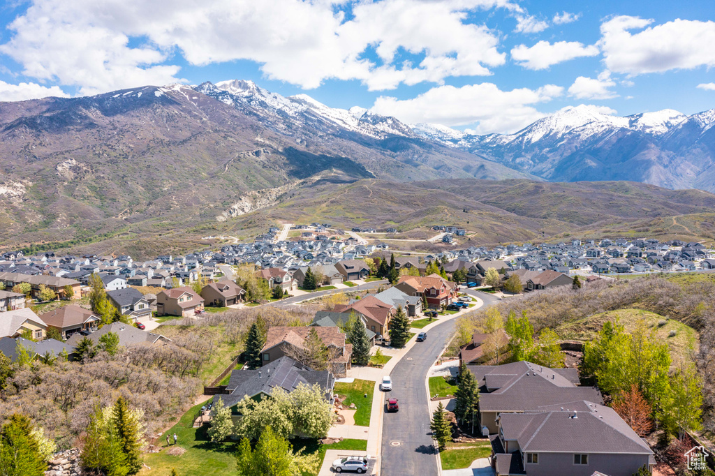 Aerial view of property and surrounding area featuring nearby suburban area and mountains