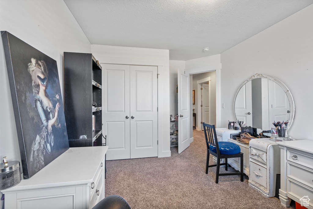 Carpeted office featuring a textured ceiling