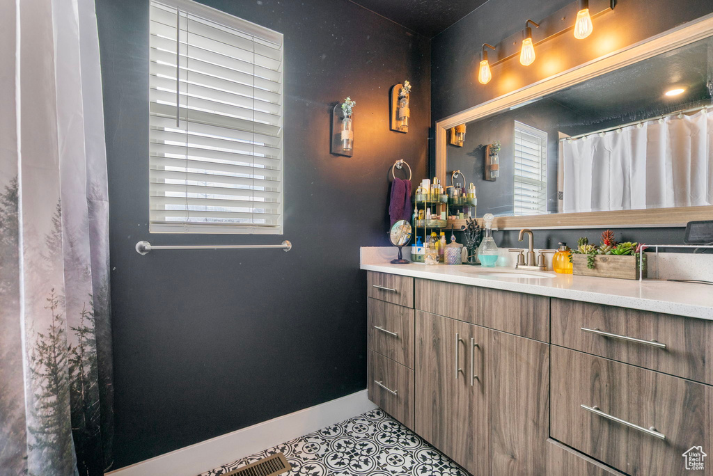 Full bathroom featuring tile patterned flooring, vanity, and baseboards