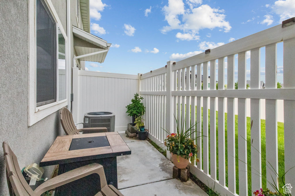 View of patio / terrace featuring central AC unit, fence, and outdoor dining area