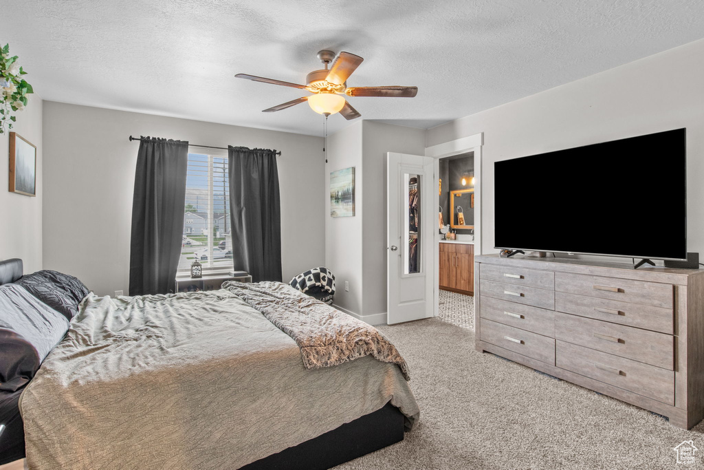 Carpeted bedroom featuring a textured ceiling, ceiling fan, and baseboards