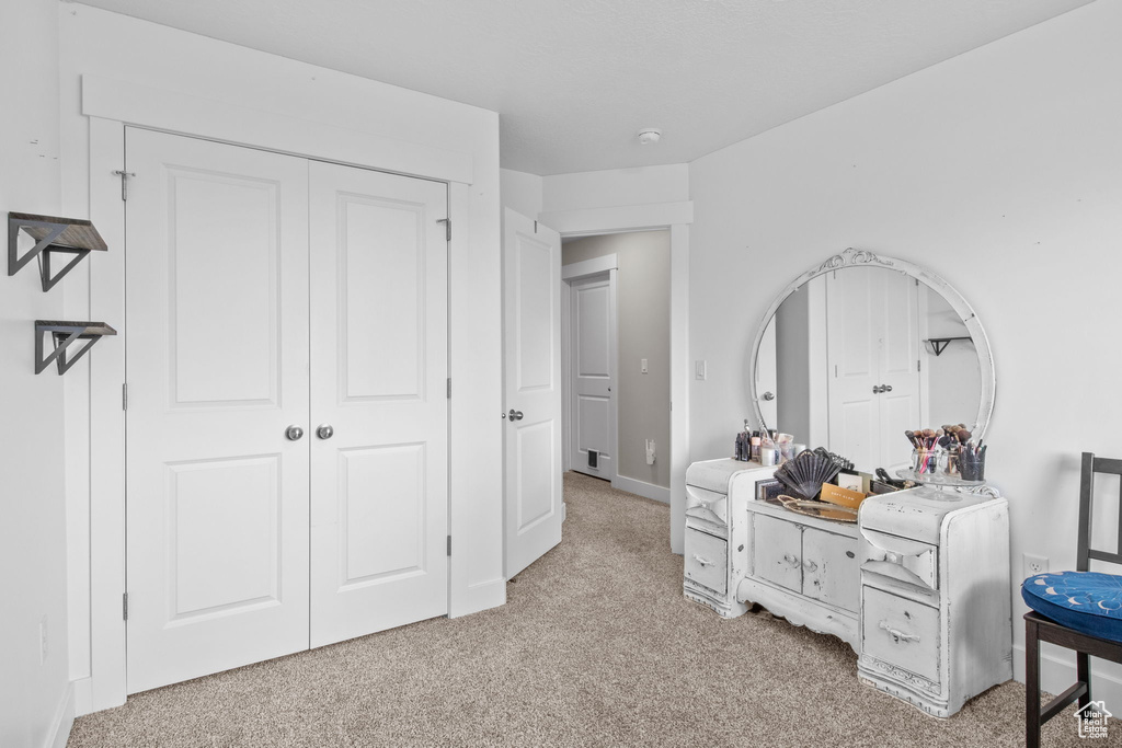 Bedroom featuring light colored carpet, a closet, and baseboards