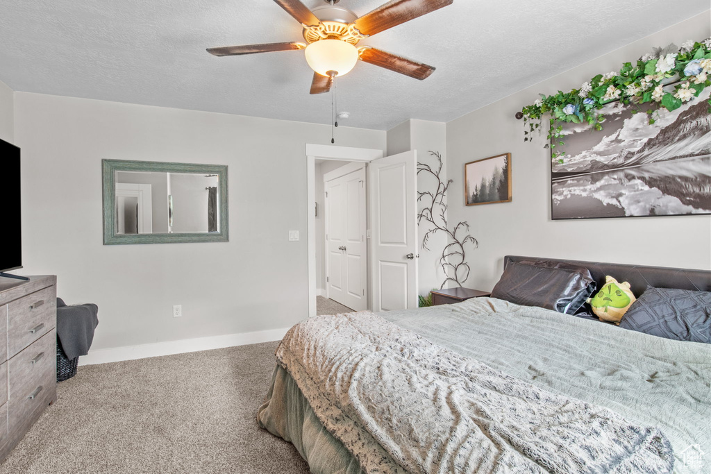 Carpeted bedroom with baseboards and a ceiling fan
