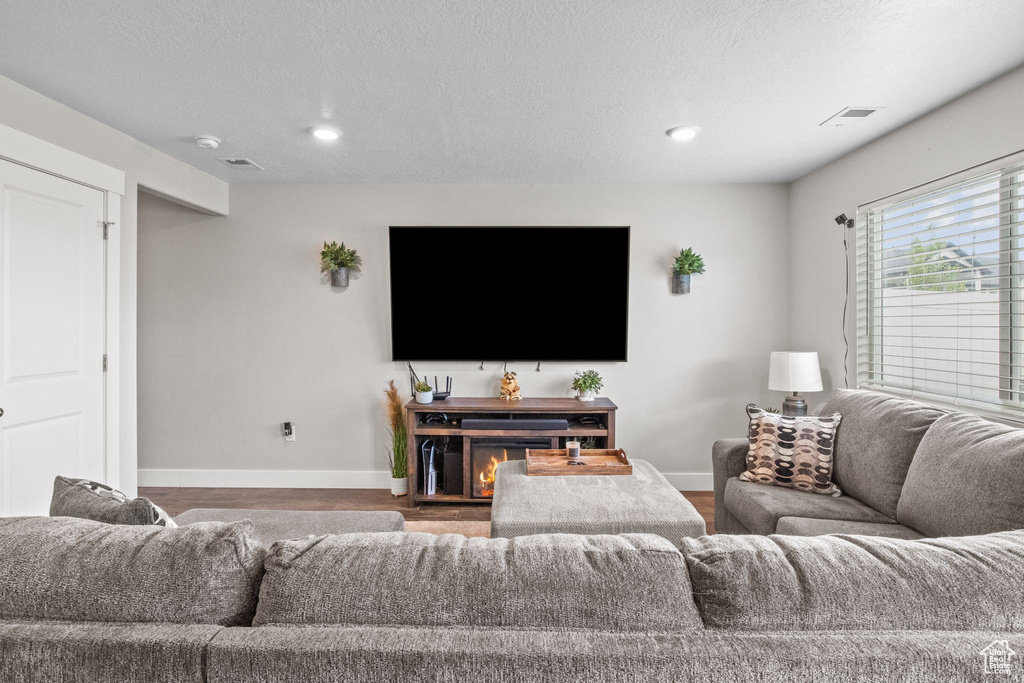 Living area featuring baseboards, recessed lighting, and wood finished floors