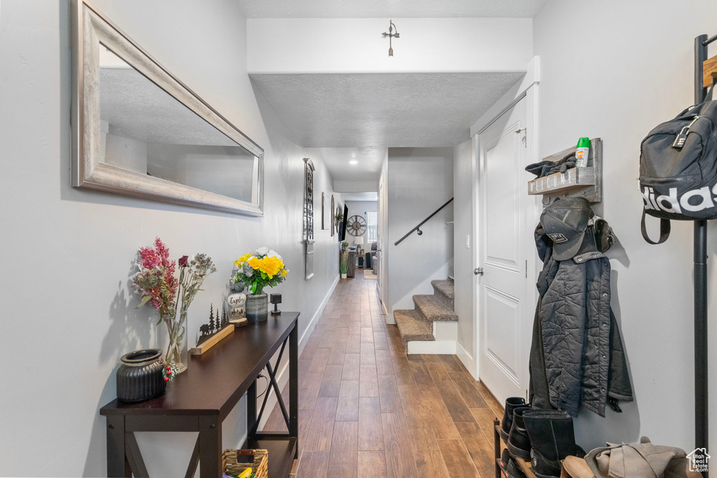 Entrance foyer featuring dark wood-style floors, stairway, and baseboards