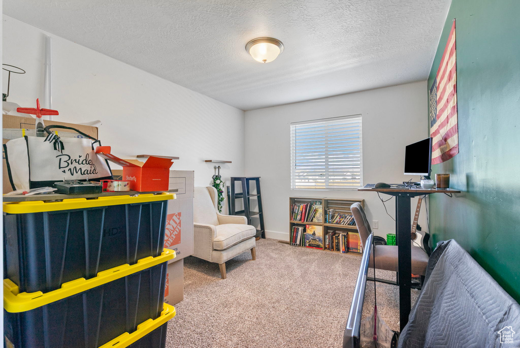 Bedroom featuring carpet floors, a textured ceiling, and baseboards