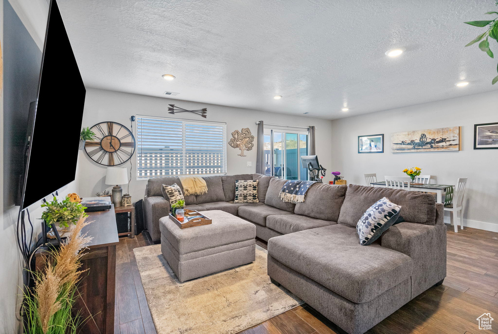 Living area with recessed lighting, a textured ceiling, and wood finished floors