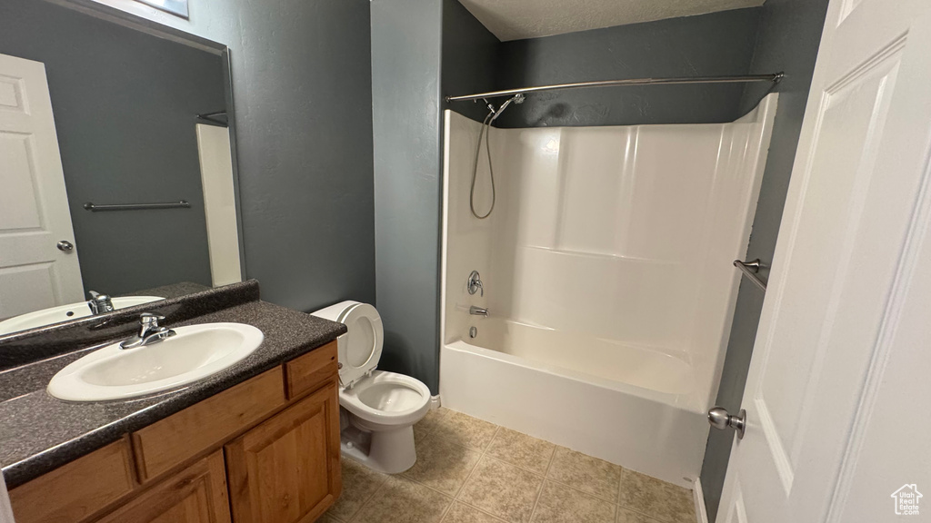 Bathroom featuring toilet, vanity, washtub / shower combination, and tile patterned floors