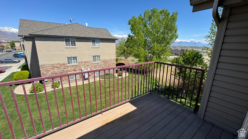 Wooden deck with a mountain view and a lawn