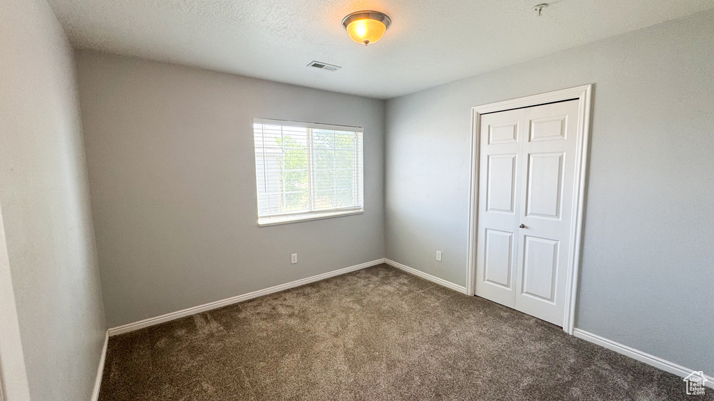 Unfurnished bedroom with carpet floors and a closet