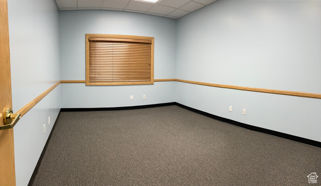 Empty room with a drop ceiling and carpet