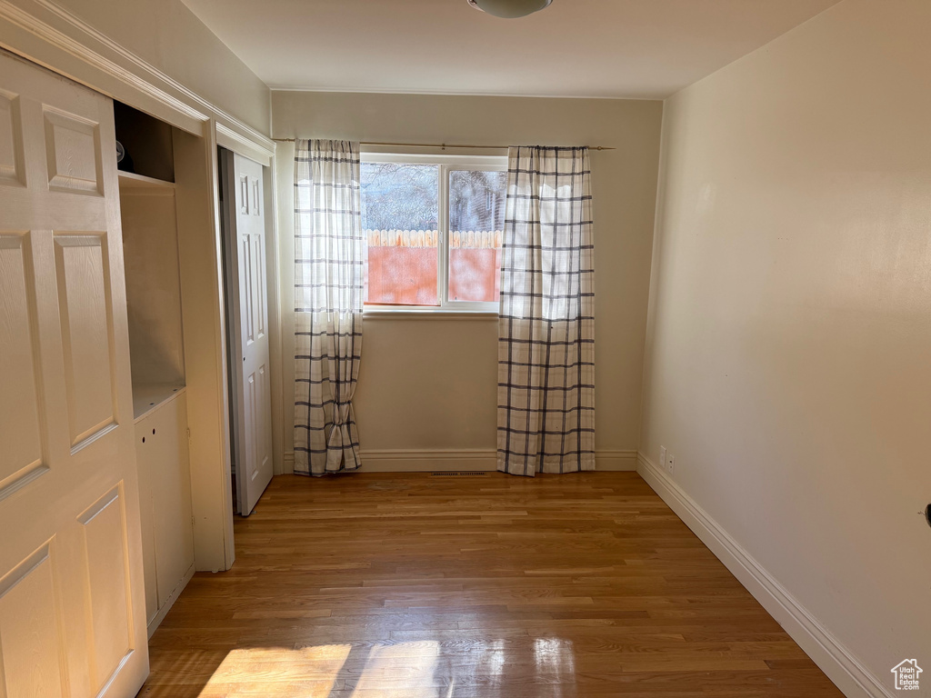 Unfurnished bedroom with light wood-style floors and baseboards