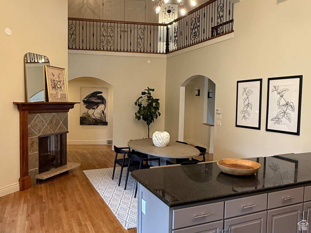 Kitchen with an inviting chandelier, a high ceiling, arched walkways, and light wood-type flooring