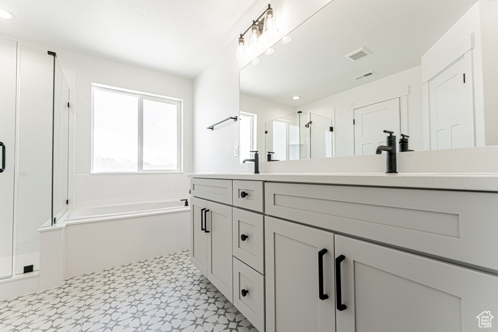 Bathroom with a stall shower, double vanity, a bath, tile patterned floors, and recessed lighting