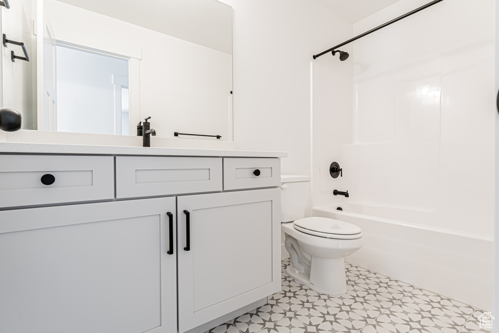 Bathroom with toilet, vanity, and  shower combination