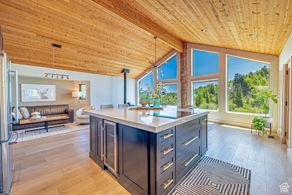 Kitchen with wine cooler, wood ceiling, open floor plan, light wood-style flooring, and freestanding refrigerator
