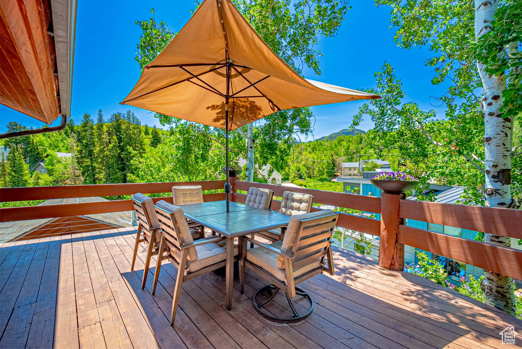 Wooden terrace featuring outdoor dining space and a mountain view