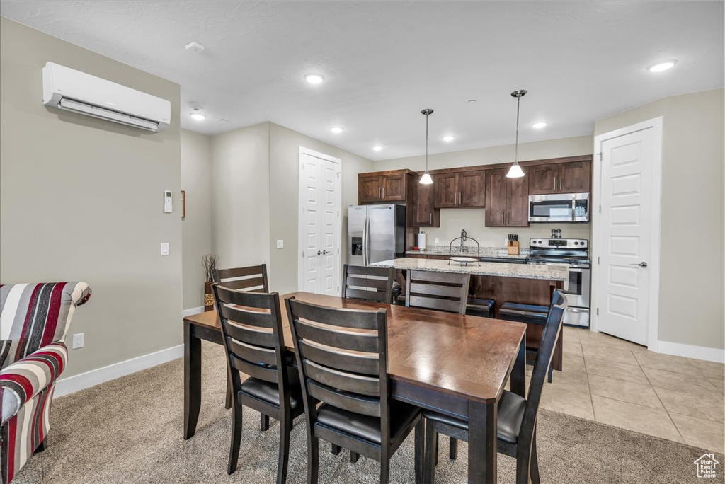 Dining area featuring light carpet, recessed lighting, baseboards, a wall mounted air conditioner, and light tile patterned flooring