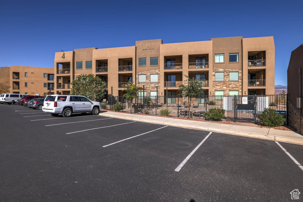 View of property with uncovered parking and fence