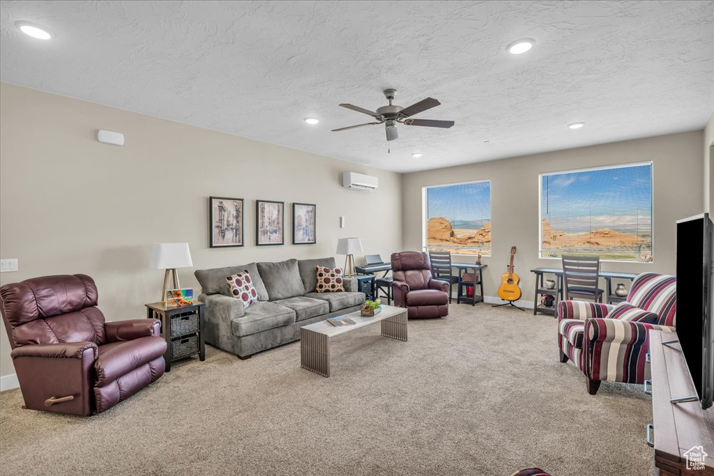 Living area with recessed lighting, light colored carpet, a textured ceiling, and a wall mounted AC