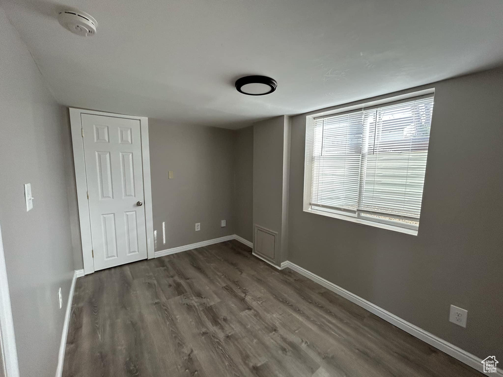 Unfurnished bedroom featuring dark wood-type flooring and baseboards