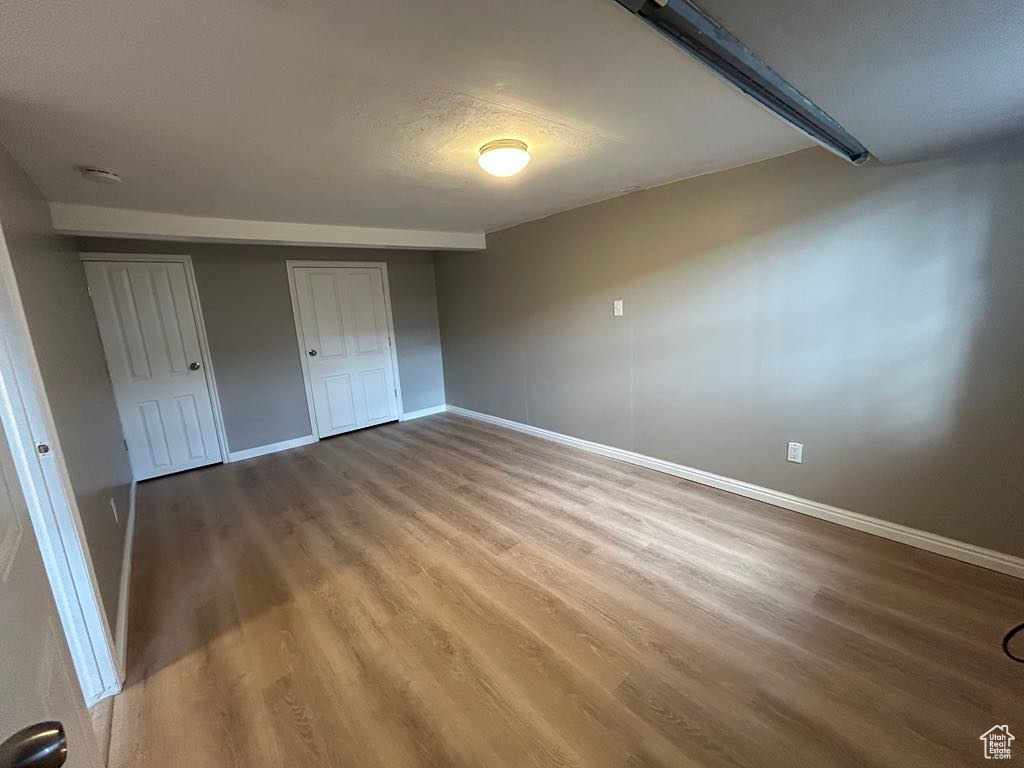 Unfurnished bedroom with baseboards and wood finished floors