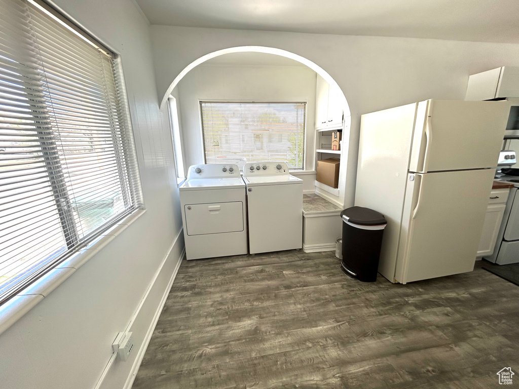 Washroom with separate washer and dryer, laundry area, dark wood-type flooring, and arched walkways