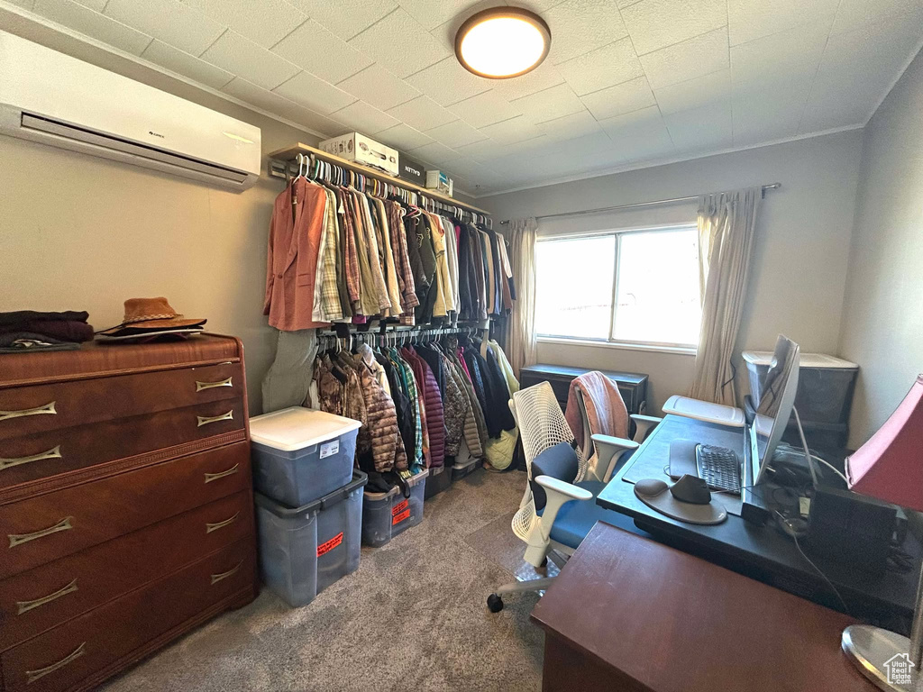 Walk in closet with carpet floors and an AC wall unit