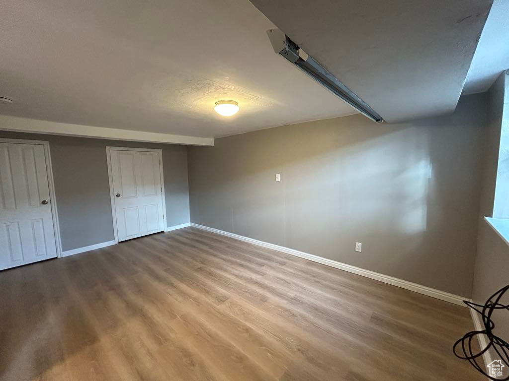 Unfurnished bedroom with a closet, baseboards, and wood finished floors