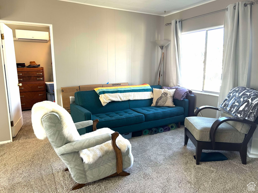 Living area featuring an AC wall unit, ornamental molding, and carpet flooring