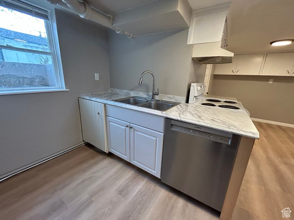 Kitchen featuring light stone counters, light wood finished floors, a sink, dishwasher, and white range with electric stovetop