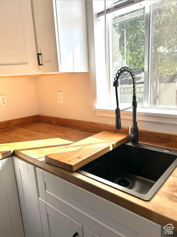 Kitchen featuring a healthy amount of sunlight, wooden counters, and a sink