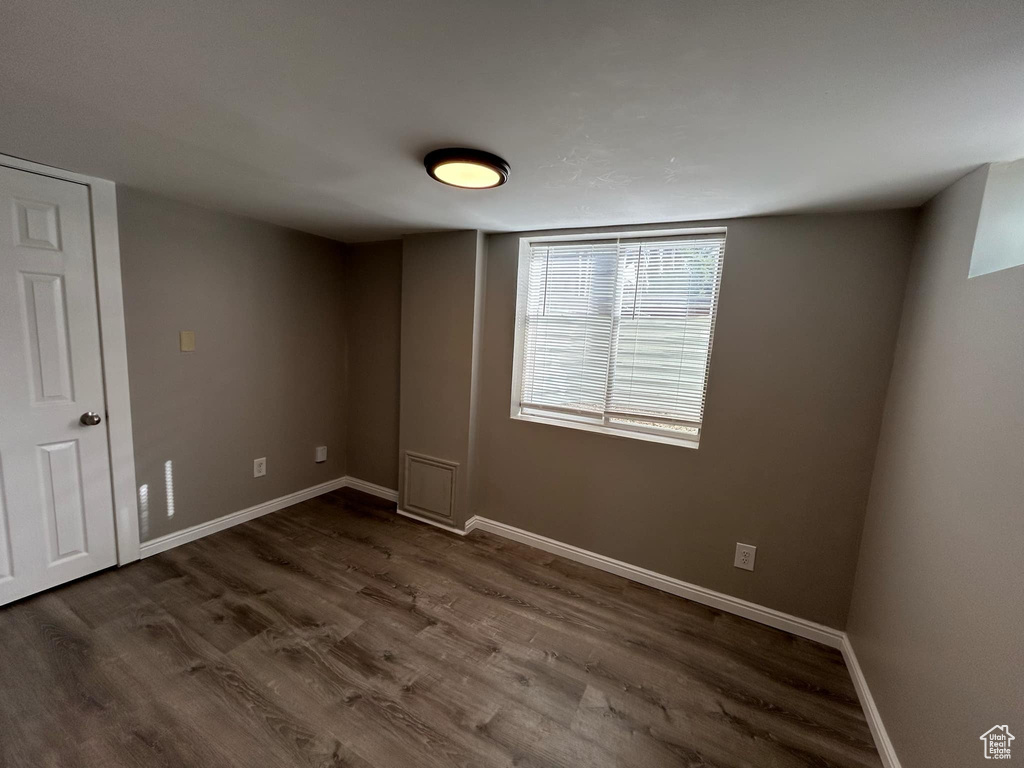 Spare room with baseboards and dark wood finished floors