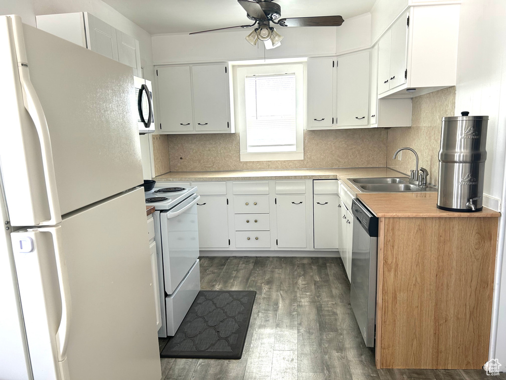 Kitchen with a sink, stainless steel appliances, dark wood finished floors, ceiling fan, and light countertops