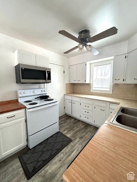 Kitchen with stainless steel microwave, dark wood-style flooring, white cabinetry, a ceiling fan, and white electric range