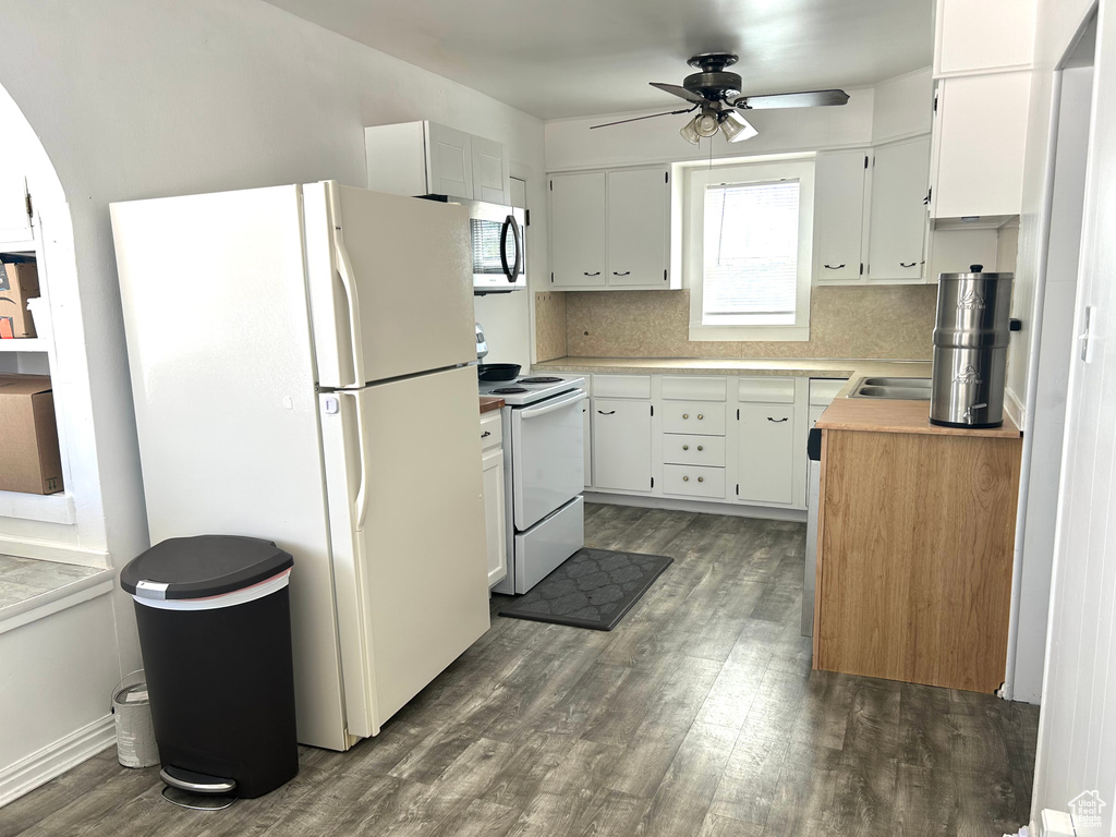 Kitchen featuring a ceiling fan, white cabinets, dark wood-style flooring, white appliances, and light countertops
