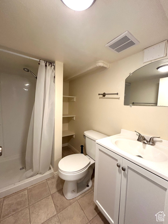 Full bathroom with a stall shower, toilet, visible vents, tile patterned flooring, and vanity