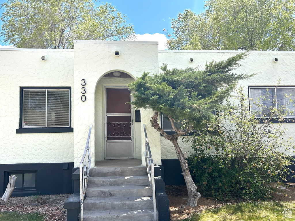Doorway to property with stucco siding