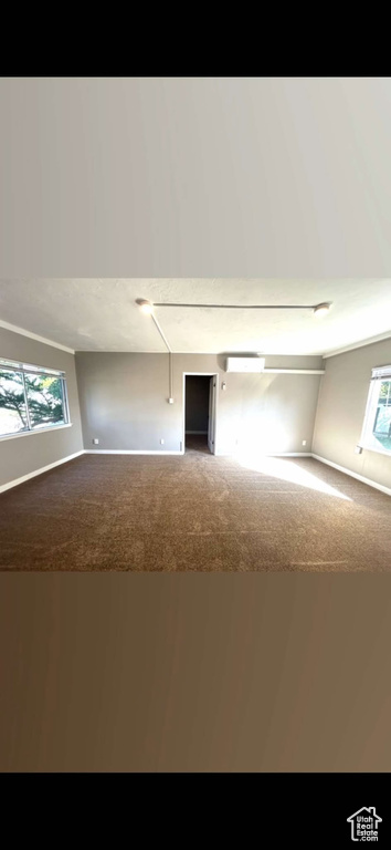 Carpeted empty room featuring baseboards