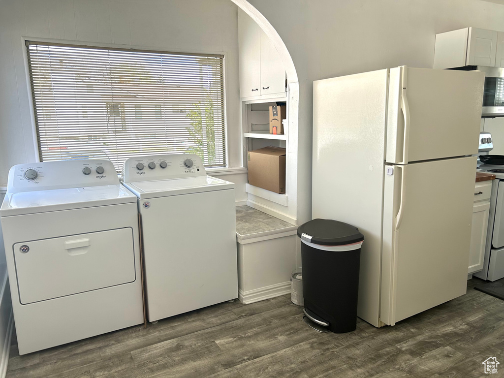 Laundry area featuring washing machine and dryer, dark wood finished floors, arched walkways, and laundry area
