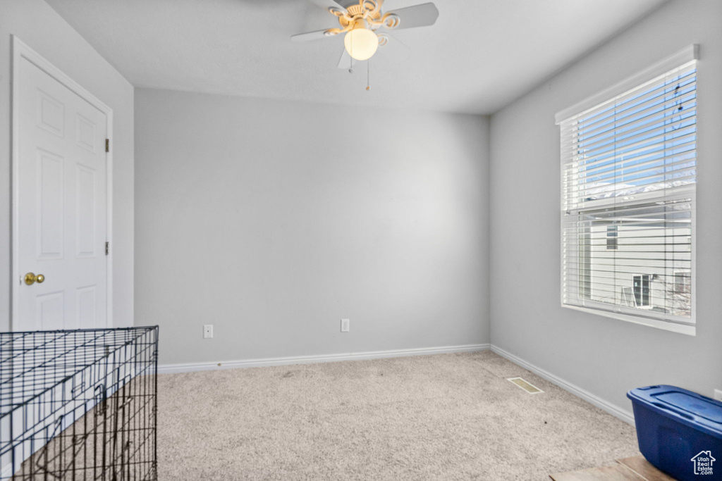 Unfurnished room with baseboards, visible vents, and light colored carpet