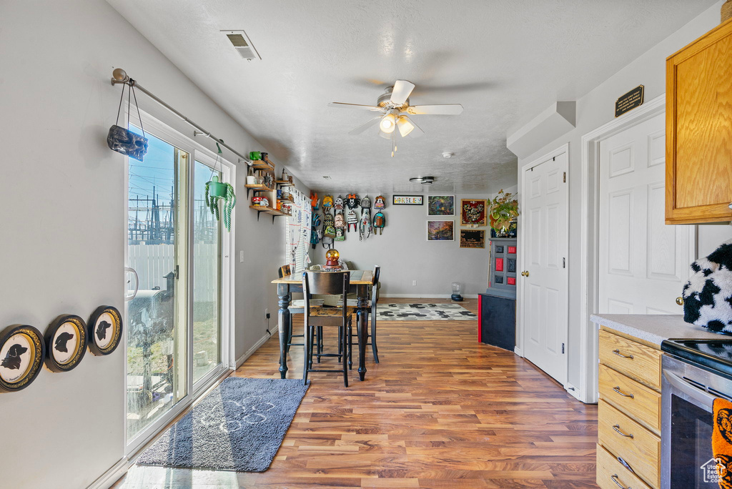 Kitchen with light countertops, visible vents, a ceiling fan, wood finished floors, and baseboards