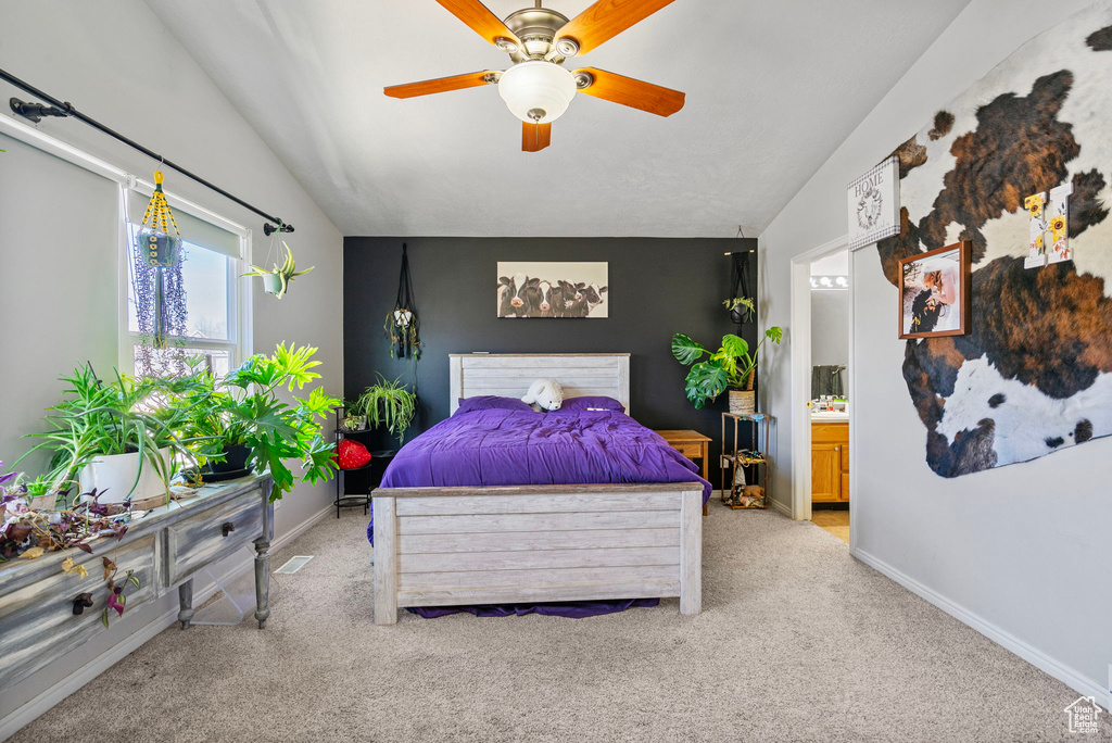 Bedroom featuring light colored carpet, vaulted ceiling, and baseboards