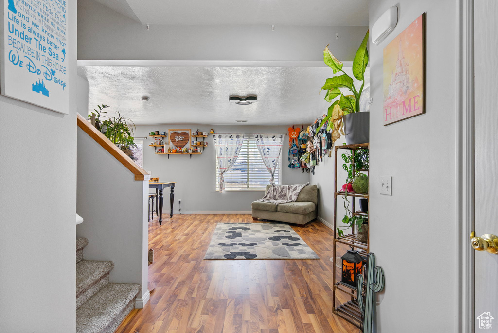 Interior space featuring stairs, a textured ceiling, baseboards, and wood finished floors