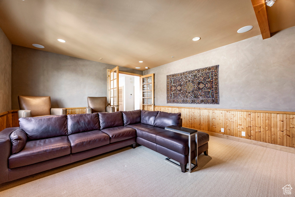 Carpeted living room with a wainscoted wall, recessed lighting, and wooden walls