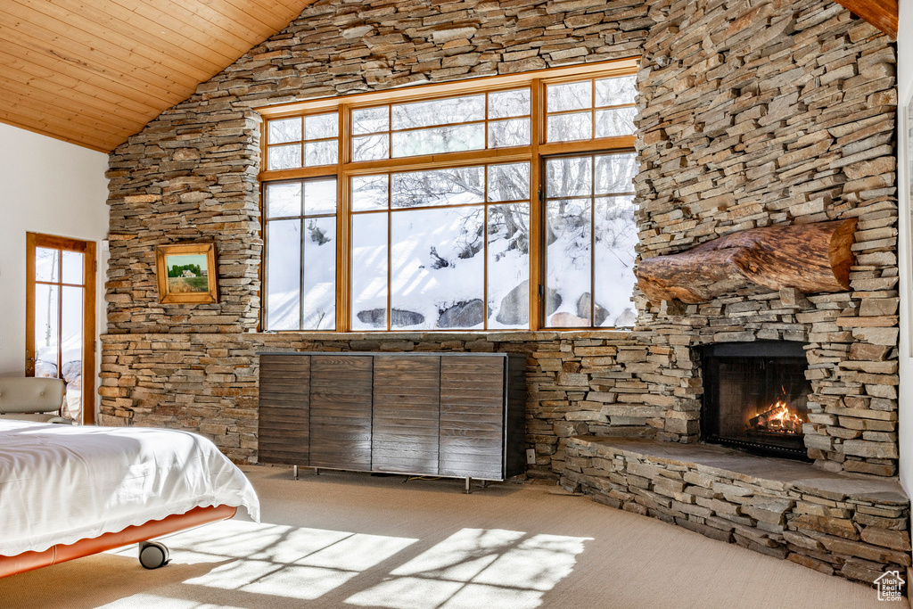 Carpeted bedroom featuring wooden ceiling, high vaulted ceiling, and a fireplace