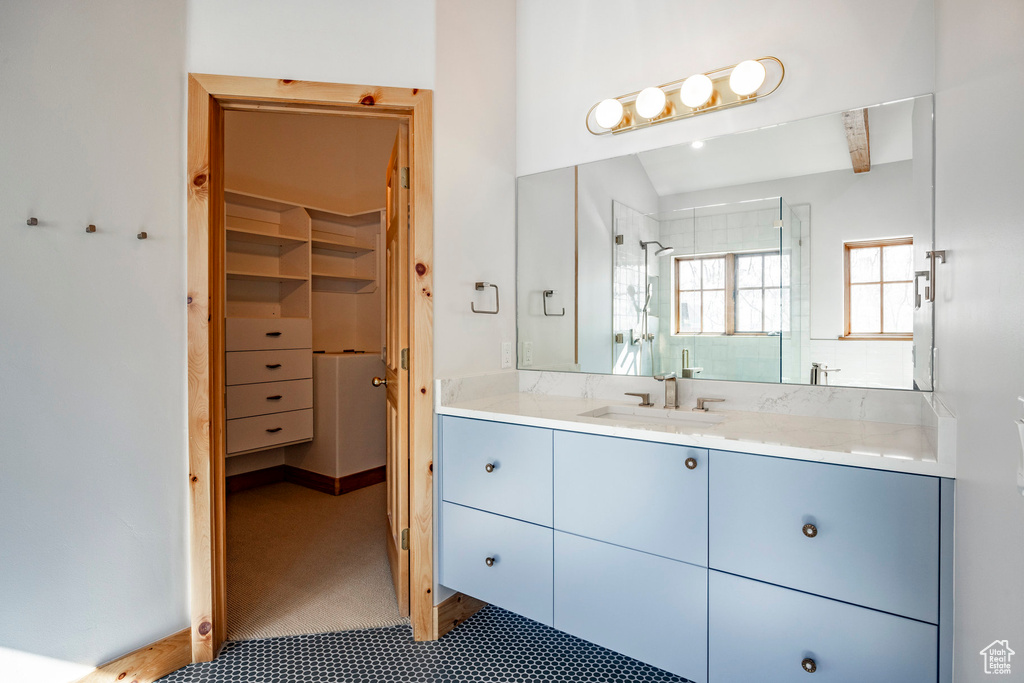 Full bathroom featuring vanity, a stall shower, and a walk in closet
