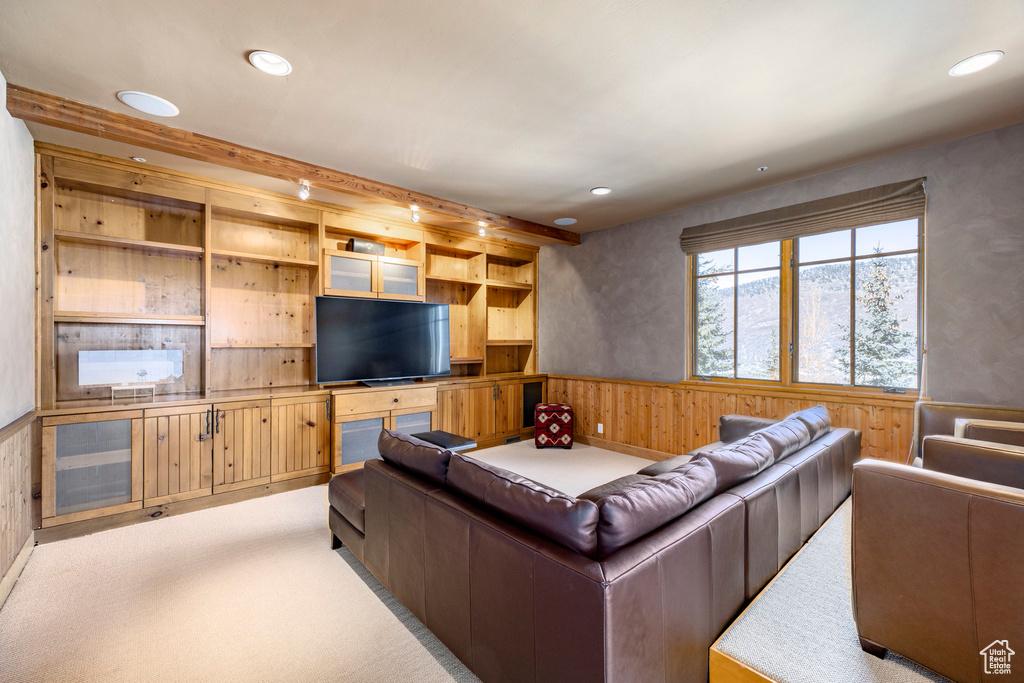 Living area featuring wooden walls, wainscoting, light carpet, and recessed lighting