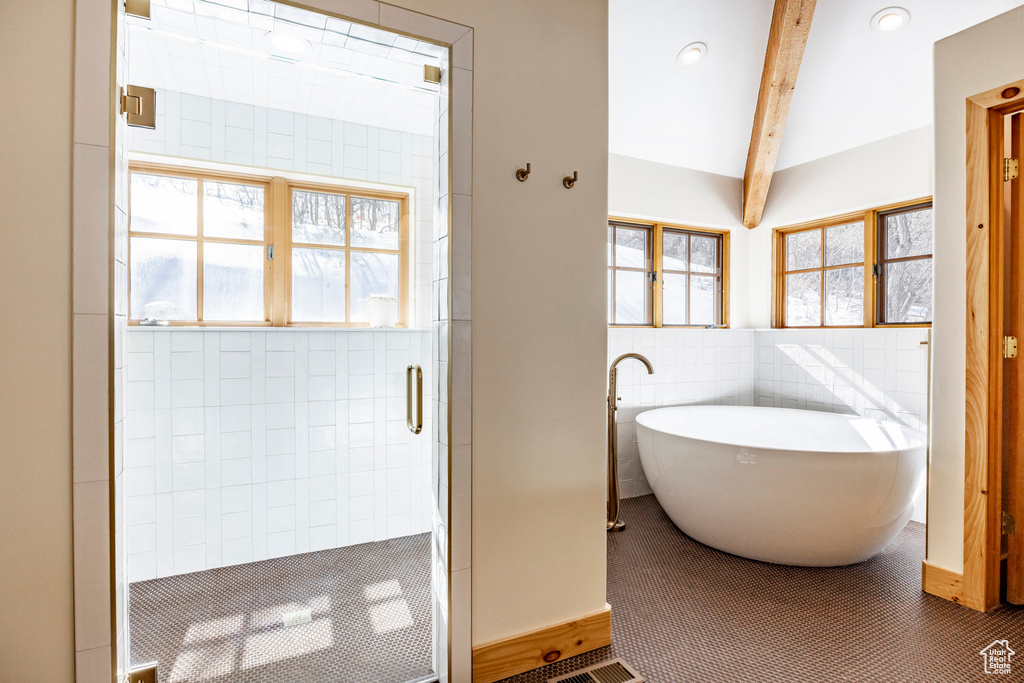 Bathroom featuring tile walls, a shower stall, a soaking tub, beam ceiling, and recessed lighting